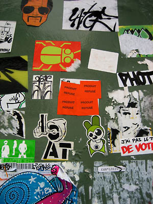 A bunch of cool stickers on a wall in Paris.