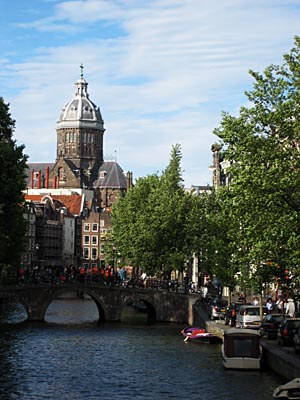 View over a canal in Amsterdam with an old church in the background.