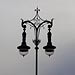 Graphic shot of an ornate lamp post against a cloudy sky in Berlin.