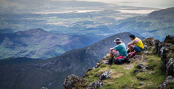 Resting hikers on mountaintop in Wales