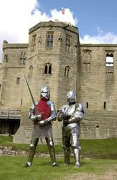 Two knights in armor outside Warkworth Castle