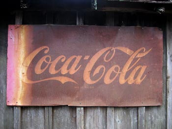 An old and weathered Coca Cola sign.