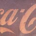 An old and weathered Coca Cola sign.