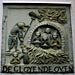 A really twisted plaque on a wall in Amsterdam with baby cherubs in an oven.