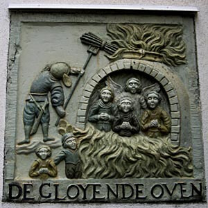 A really twisted plaque on a wall in Amsterdam with baby cherubs in an oven.