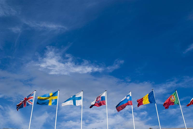 String of flags against a deep blue sky in Montpellier, France.